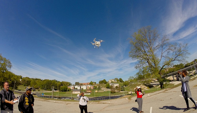 Lincoln University journalism students observe as assistant professor Will Sites, left, pilots a DJI Phantom 3 drone. (Kelsey Bias)